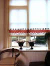 Jasna roleta ozdobiona wzorzystą taśmą w kontrastowym kolorze
